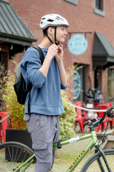Boy buckling bicycle helmet